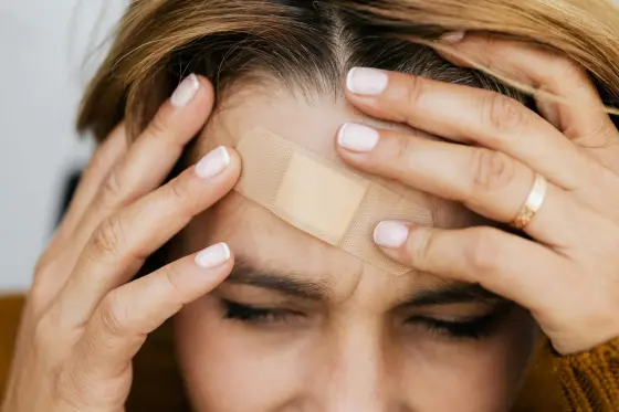 Migren atağı geçiren kişi alnını tutarak ağrıyla mücadele ediyor