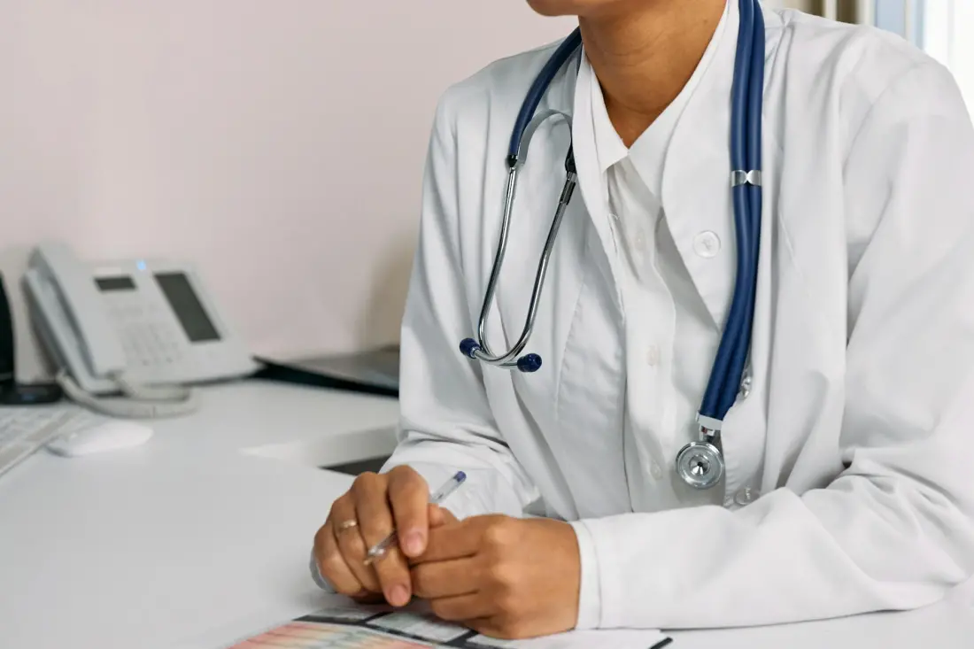 Beyaz önlüklü doktor masada steteskop ile