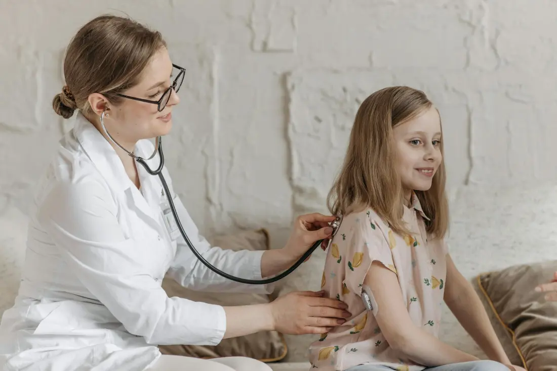 Doktor genç hastaya steteskop ile muayene