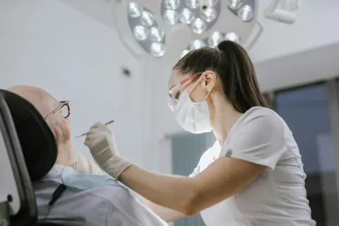 Modern diş kliniğinde diş hekimi muayene yapıyor