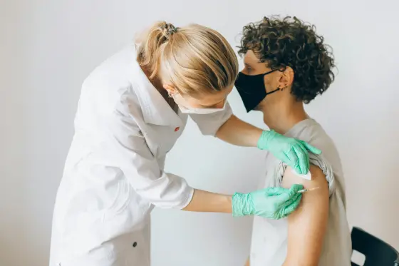 Sağlık çalışanı aşı uyguluyor — hepatit B aşısı koruma