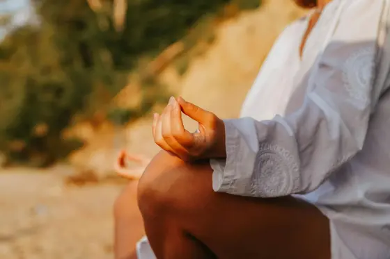 Gün batımında sahilde meditasyon yapan kişi — stresle başa çıkma